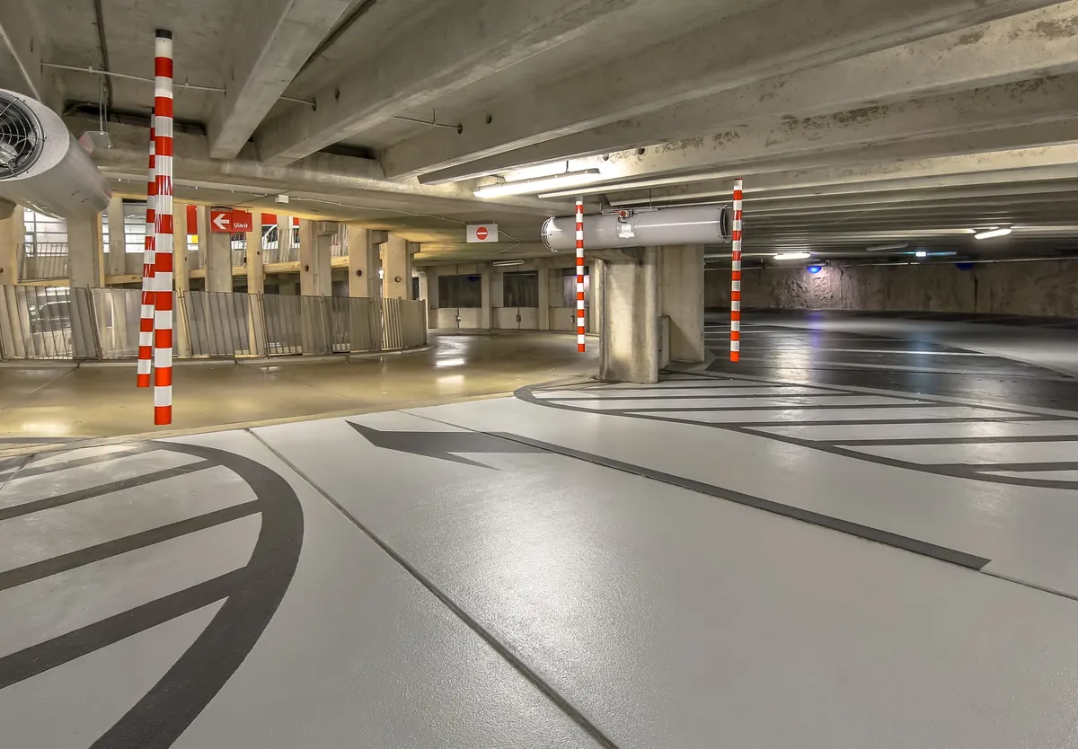 Commercial parking garage with glossy epoxy floor, yellow safety lines and painted walkway zones